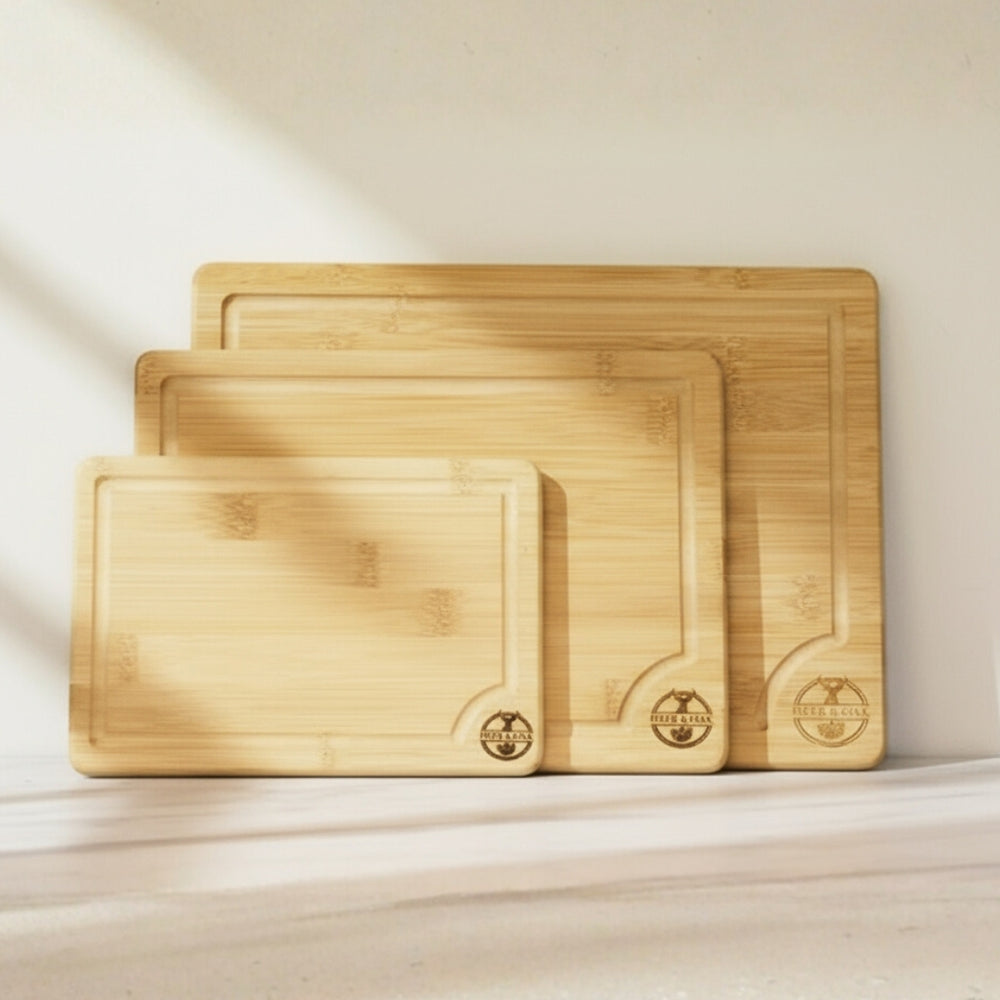 Set of three bamboo cutting boards with engraved logo on a light background